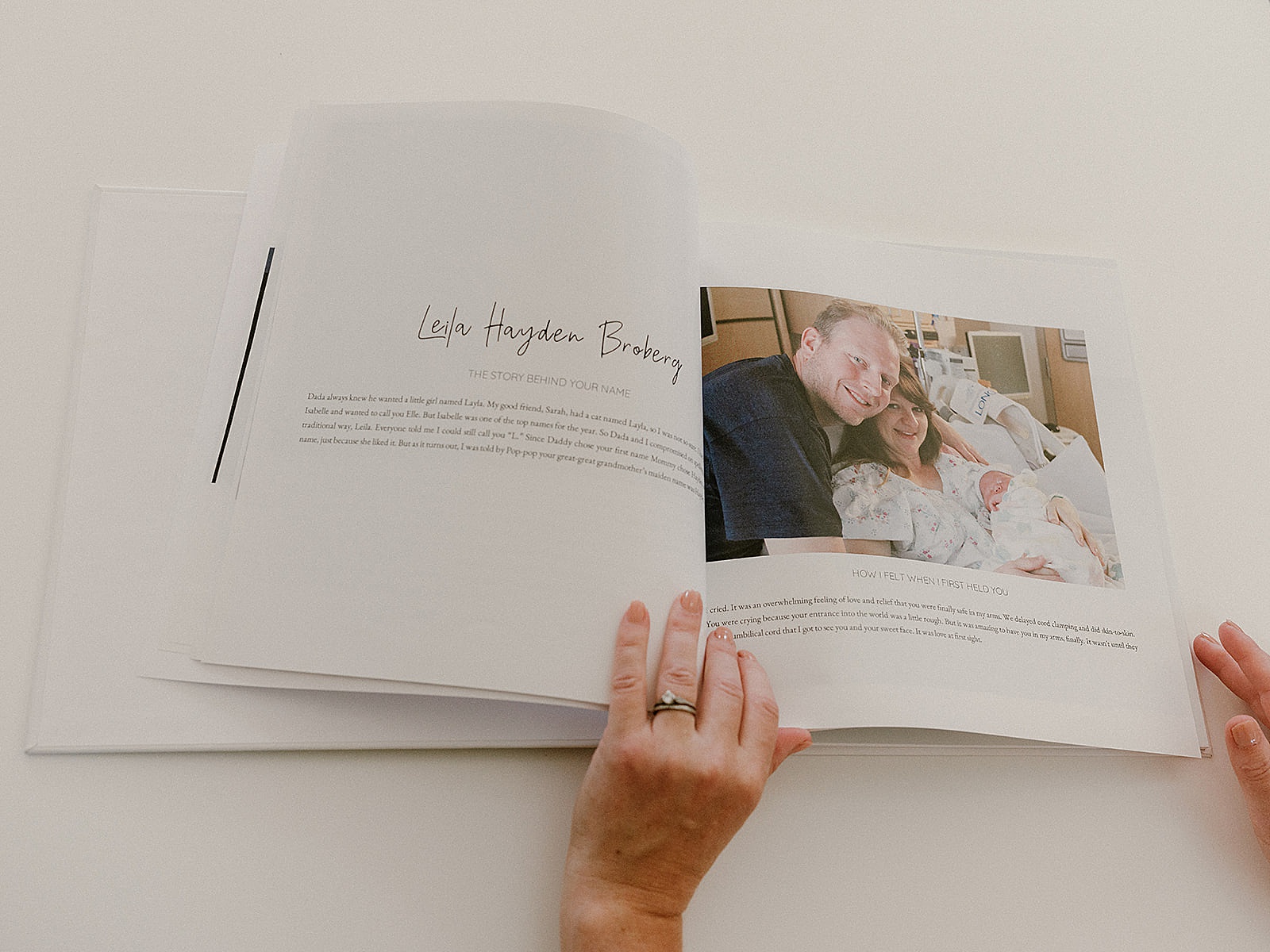 A baby book shows a couple holding a newborn in a hospital bed.