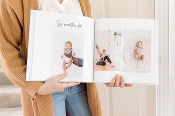 A mom holds open a baby book with her favorite memory book ideas.