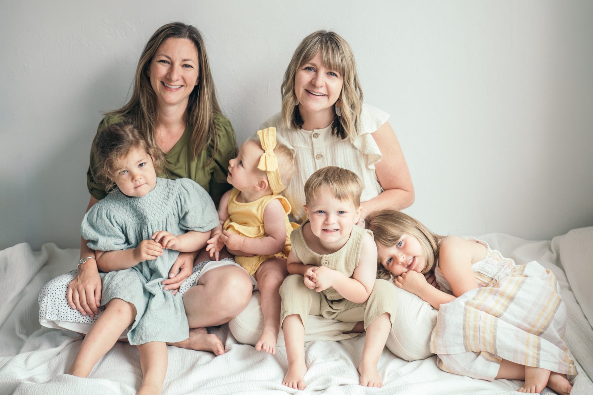 Two moms who are the co-founders of the baby book app with their 4 children